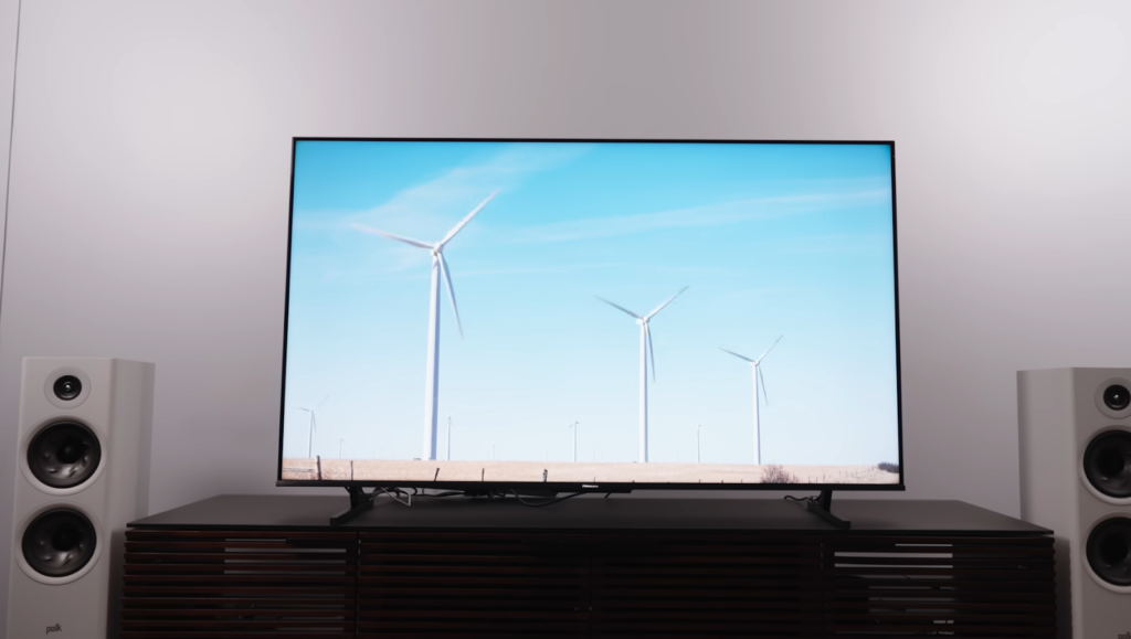 the TV on the nightstand with windmills and blue sky on it, the columns on both sides